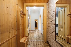 A wooden hallway with a stone wall and a door at the end. - Native Apartments Krasińskiego 21 (Kraków)