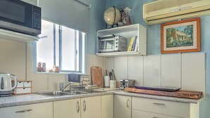 A kitchen with a microwave, toaster, sink, and cabinets.