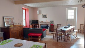 Un salon avec un canapé, une table à manger et un téléviseur.