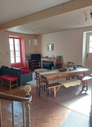 A living room with a sofa, a dining table, and a TV.