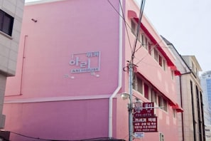 A pink building with a sign that reads 'ARI HOUSE.' - Ari House (Seoul)