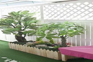 A garden with potted plants and a wooden fence. - Ari House (Seoul)