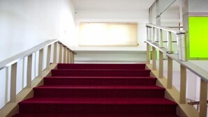 A staircase with red carpeted steps and white railings.
