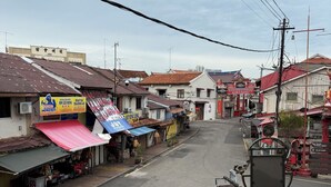 A street view with various shops and buildings, including a sign for 'KIRIN BISTRO' and a 'MONSTER' sign. - The Backpackers Hut @ Jonker Melaka (Malacca City)