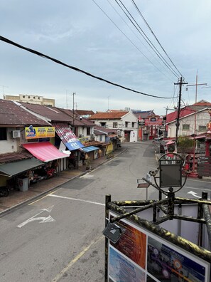 A street view with various shops and buildings, including a sign for 'KIRIN BISTRO' and a 'MONSTER' sign. - The Backpackers Hut @ Jonker Melaka (Malacca City)