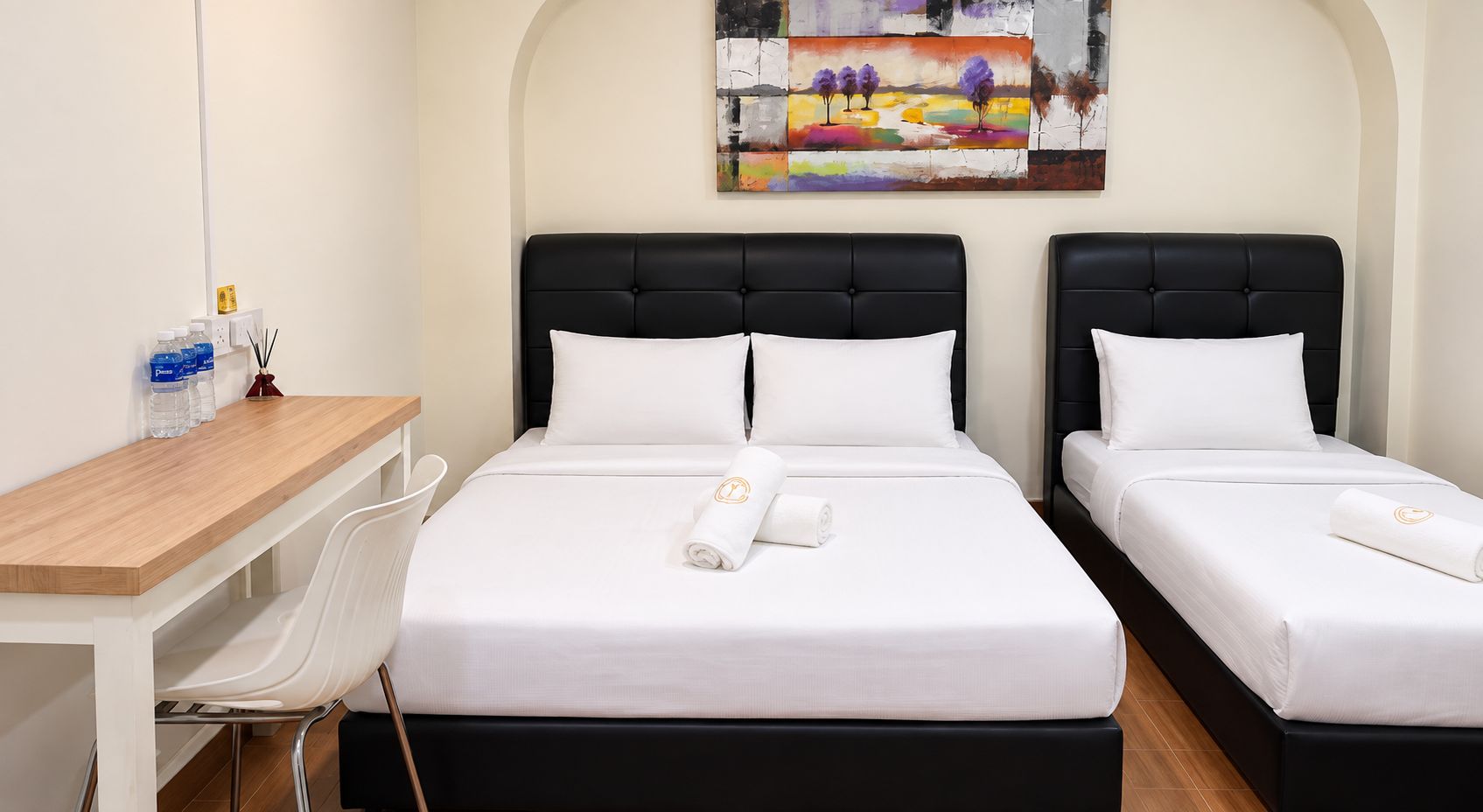 Una habitación de hotel con dos camas, un escritorio y una silla.