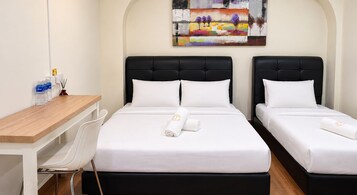Una habitación de hotel con dos camas, un escritorio y una silla.