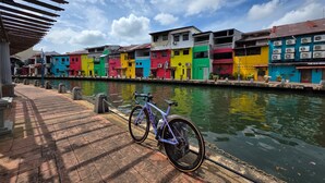 Un canal con edificios de colores vibrantes en un lado y una bicicleta estacionada junto al agua.