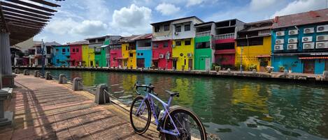 A canal with colorful buildings on one side and a bicycle parked by the water.