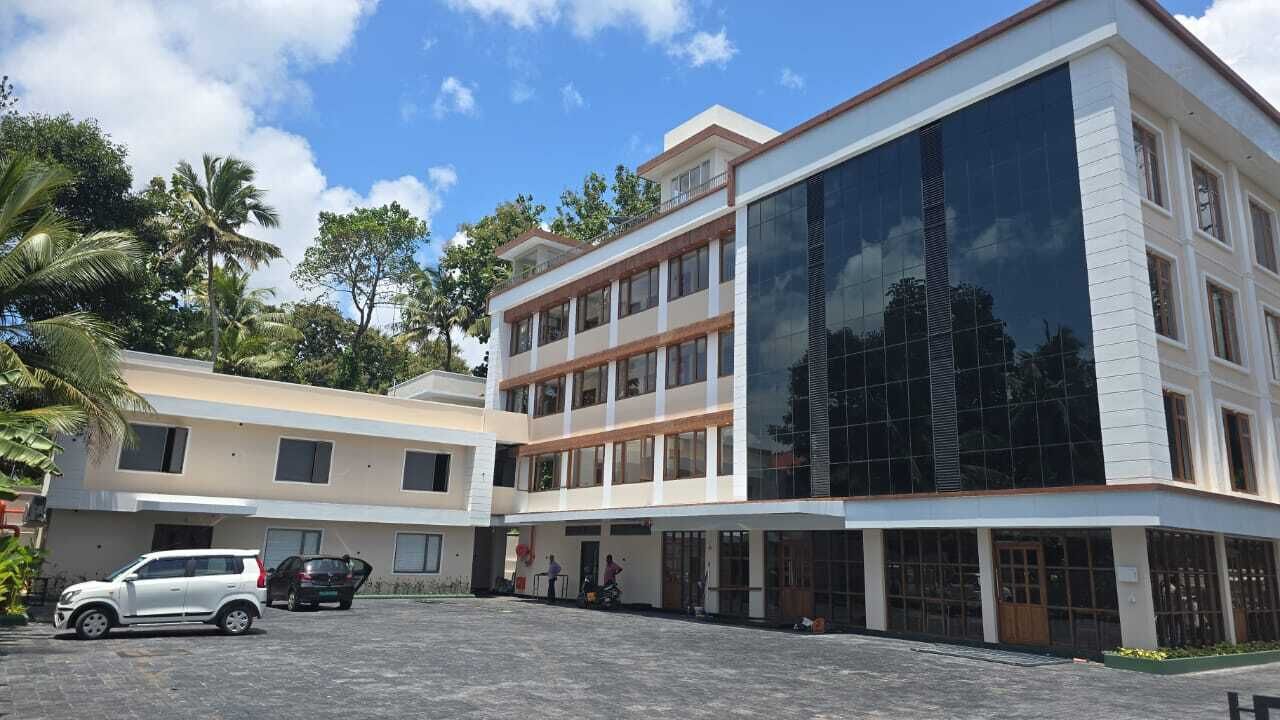 A multi-story building with a modern design, featuring large glass windows and a flat roof.