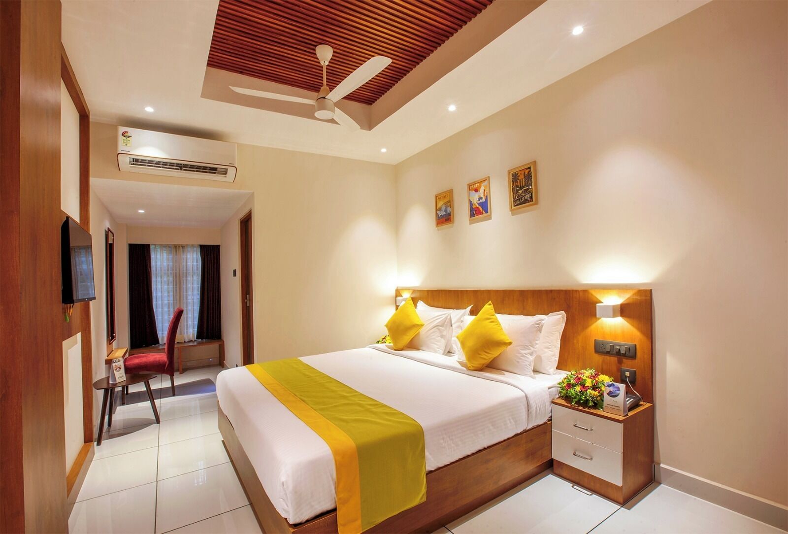 A hotel room with a bed, bedside table, lamp, and a ceiling fan.