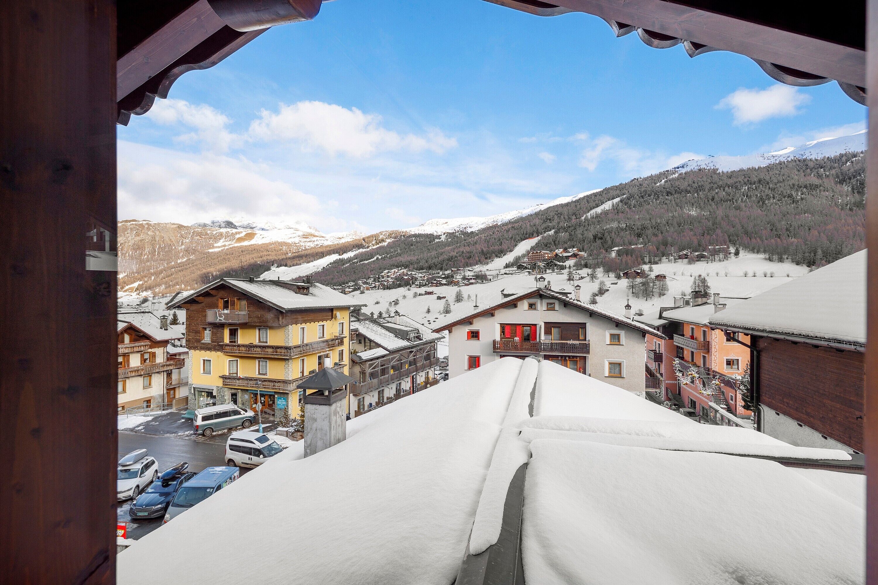 A snow-covered mountain town with buildings and a ski lift.