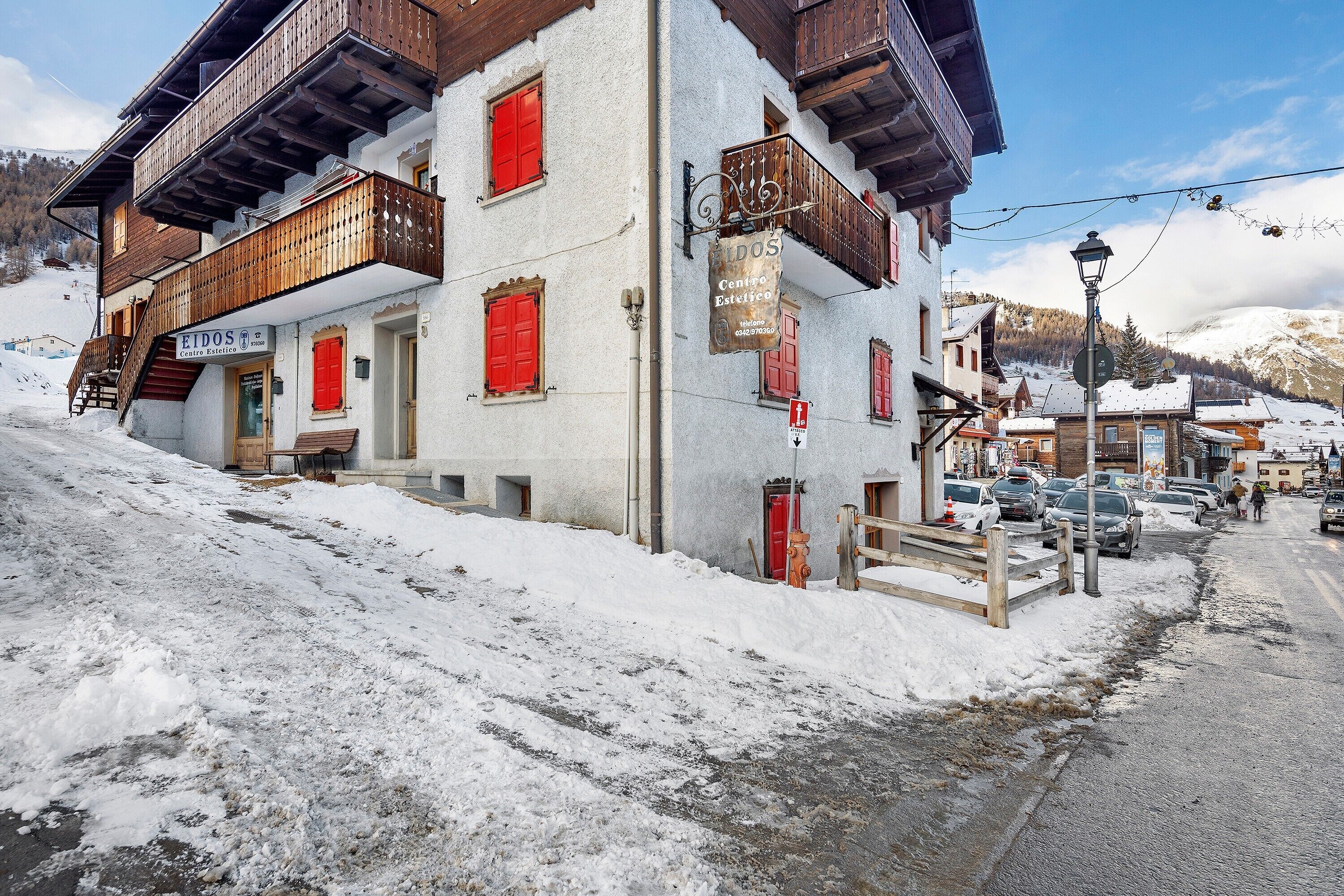 Un bâtiment avec une enseigne indiquant « ETDOS Centro Estelfece », un balcon en bois et une rue recouverte de neige.