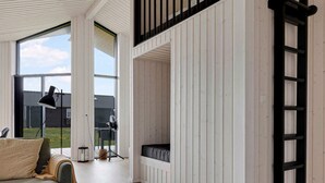 A room with a wooden floor, a sofa, a ladder, and a window with a view of the outside. - 5 Star Holiday Home in Horve (Ronde)