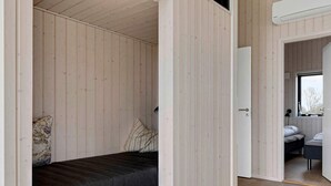 A bedroom with a bed, a window, and a door leading to another room. - 5 Star Holiday Home in Horve (Ronde)