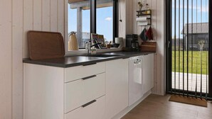 A modern kitchen with a large window, wooden cabinets, a black countertop, and a view of the outdoors. - 5 Star Holiday Home in Horve (Ronde)