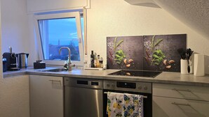 A modern kitchen with a window, stainless steel appliances, and a decorative backsplash. - Casa Lina - modern, central, in the countryside, close to trade fairs, Alsace & Karlsruhe, lovingly (Rheinstetten)