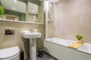 Un baño moderno con inodoro, lavabo y bañera.