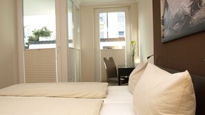 Une chambre d’hôtel avec un lit, un bureau et une chaise.