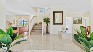 A spacious lobby with a marble floor, a staircase, and potted plants. - Villa Maria 4BRM Home (Clear Island Waters)
