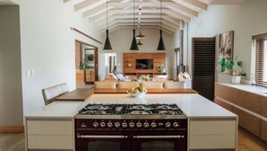 Una cocina moderna con una isla central, estufa a gas e iluminación colgante.