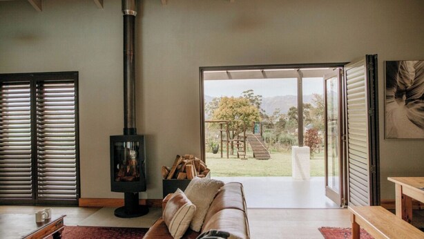 Una sala de estar moderna con chimenea, un sofá y vistas al exterior.