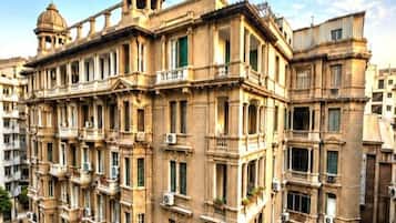 Un immeuble à plusieurs étages, de style architectural classique, doté de balcons et surmonté d’un dôme central.