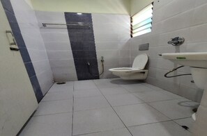 Een kleine badkamer met toilet, wastafel en douche.