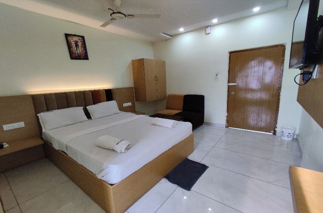 Ein Hotelzimmer mit Bett, Kleiderschrank, Schreibtisch und Fernseher.