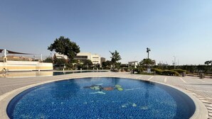 Una piscina circular con borde de azulejos, rodeada por un sendero empedrado.