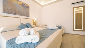 Habitación triple estándar, balcón | Caja fuerte, cortinas opacas, tabla de planchar con plancha
