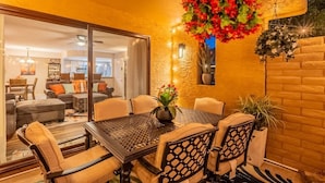 An outdoor dining area with a table and chairs, a potted plant, and a hanging floral arrangement. - Starlight Escape - Heated Pool & Spa by Old Town! (Scottsdale)