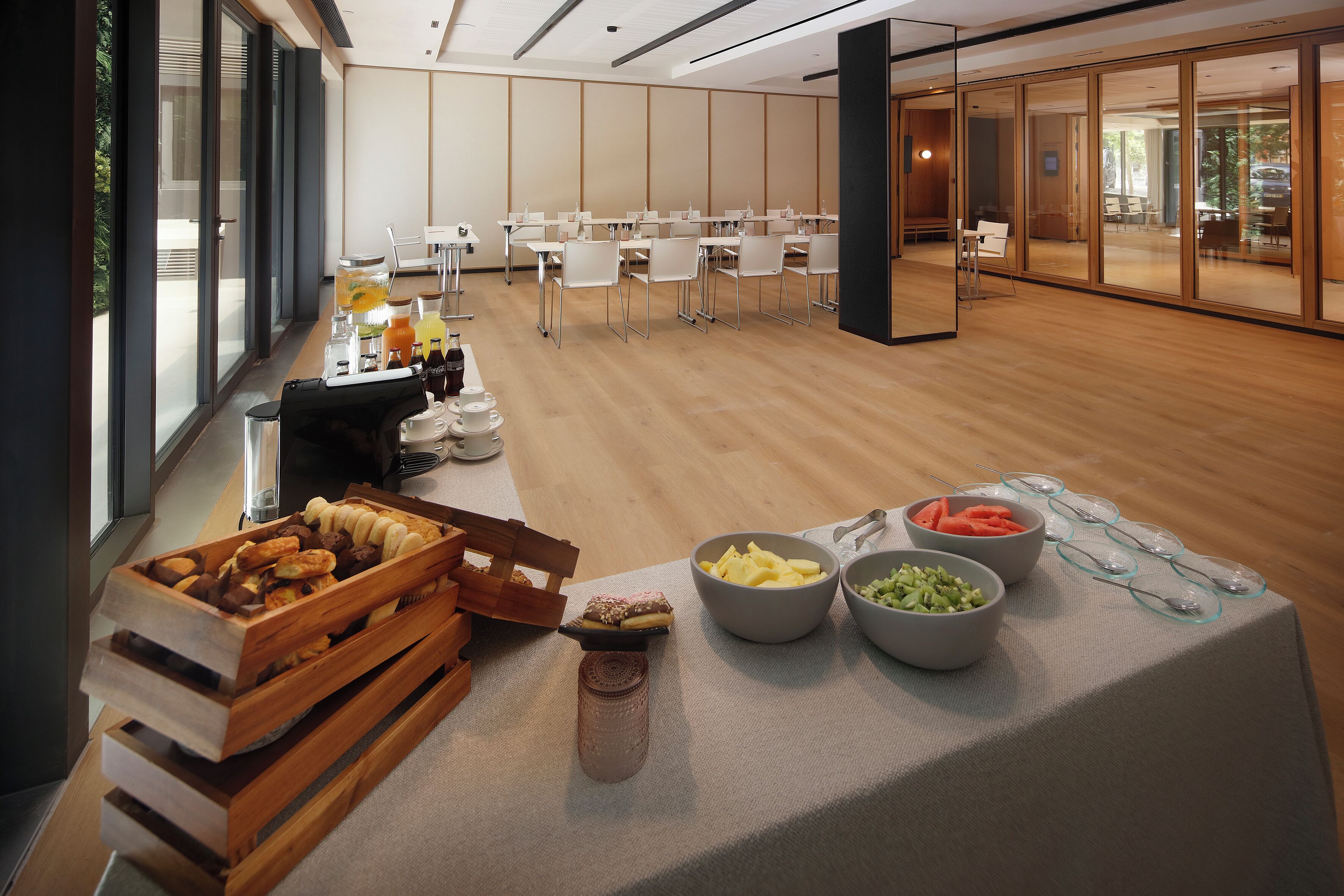 Une salle de conférence équipée de tables, de chaises et d’un buffet proposant des plats et des boissons.