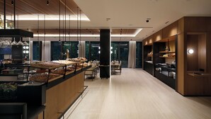 Un interior moderno con una barra central, zona de estar y grandes ventanales.