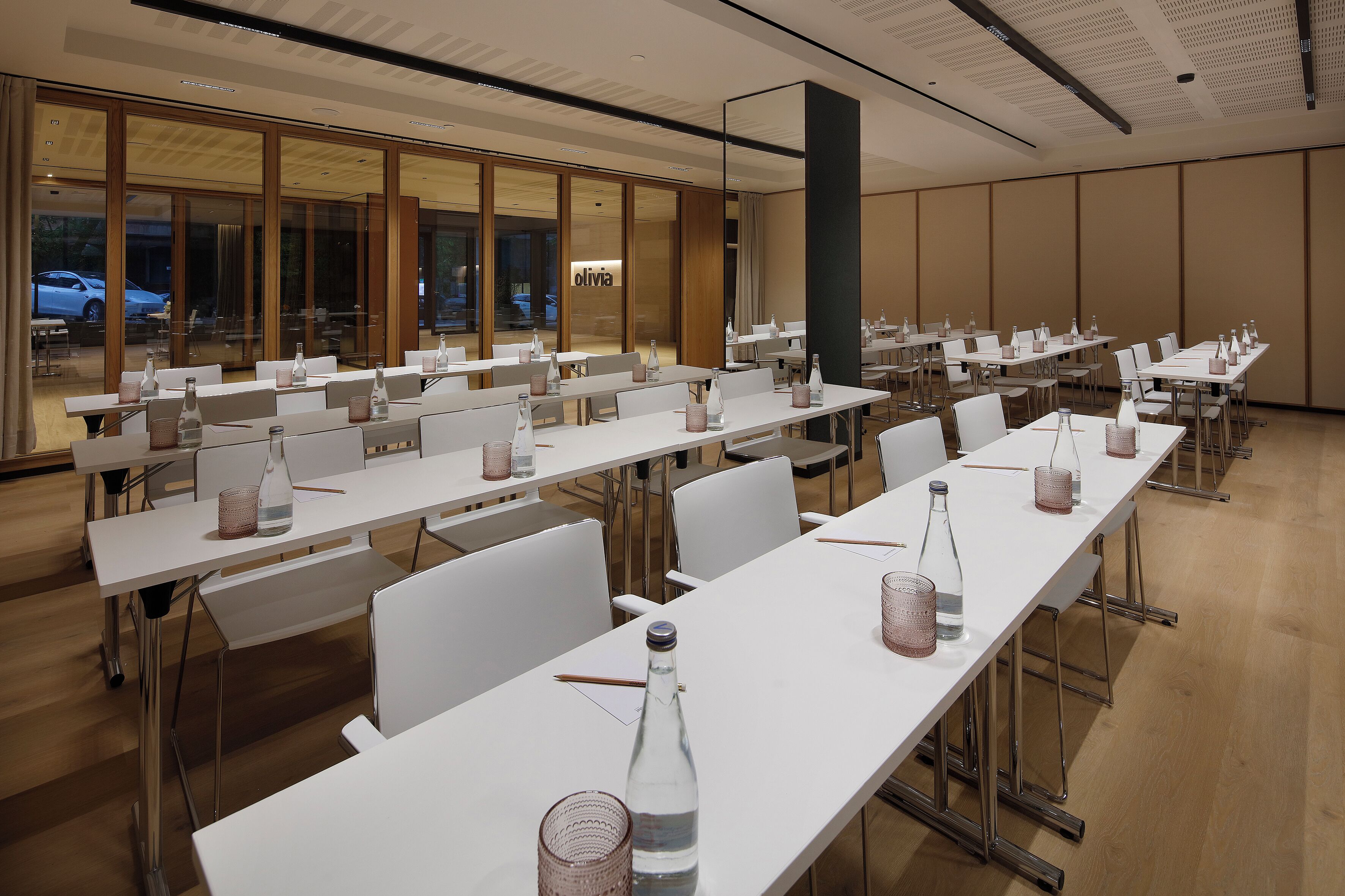 A conference room with long tables, chairs, and water bottles.