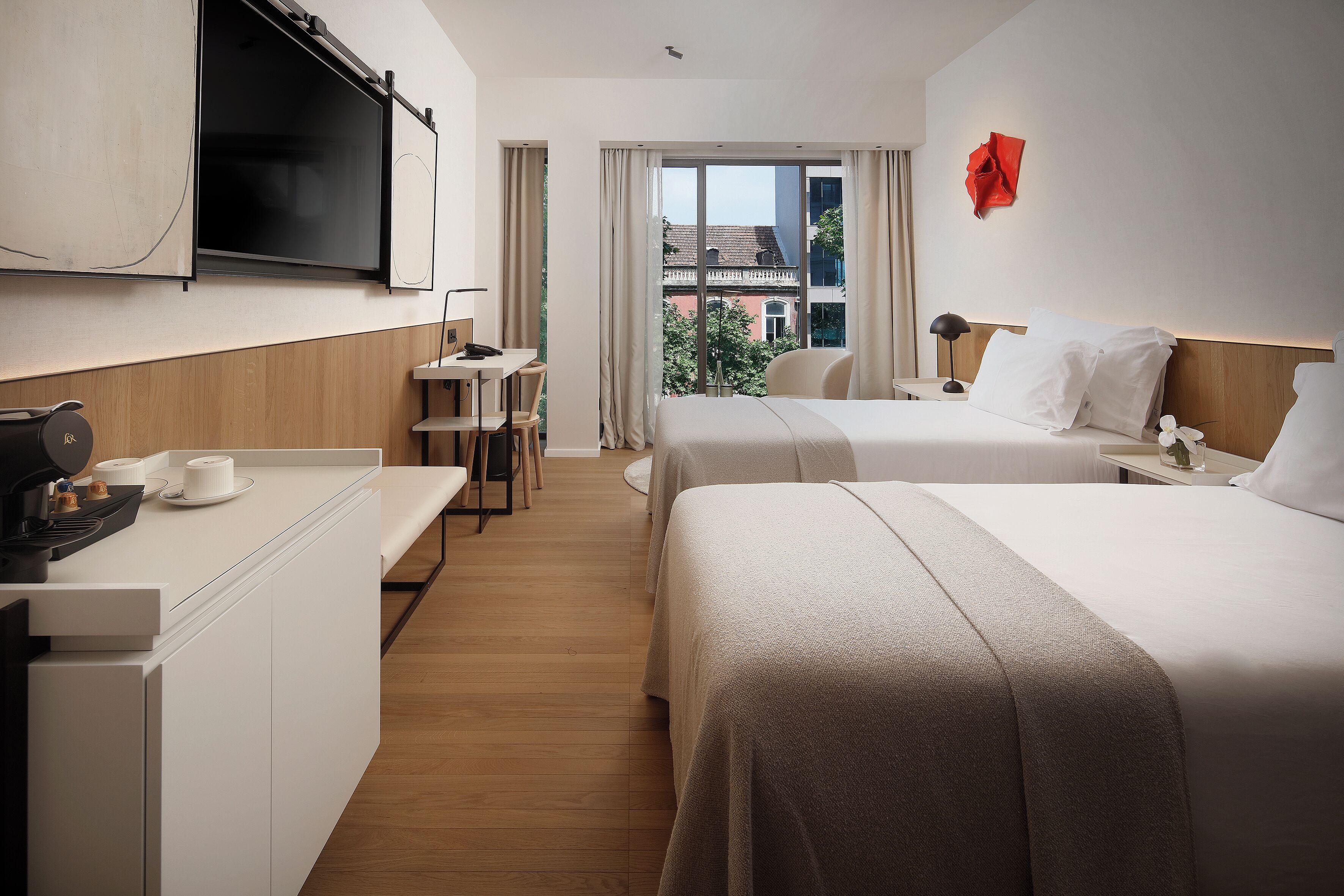 Habitación de hotel con cama, mesita de noche, televisor y un escritorio con silla.