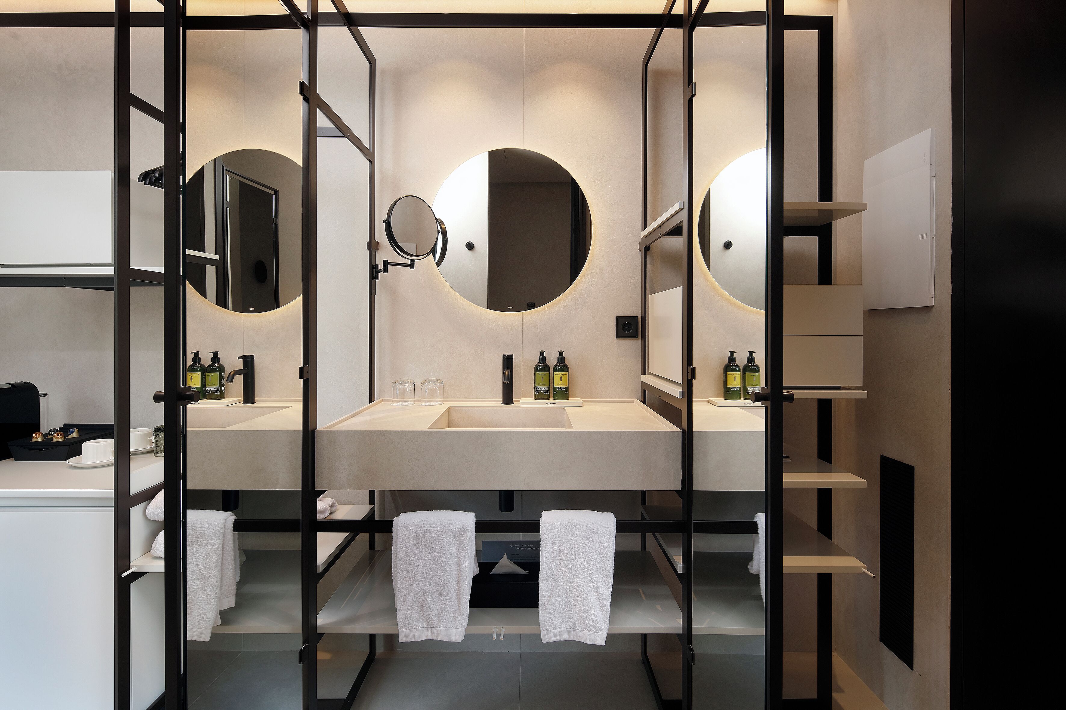 A modern bathroom with two sinks, mirrors, and towel racks.