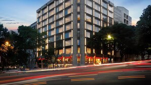 Un hotel moderno con un llamativo letrero que dice 'olivia', varios pisos y una fachada bien iluminada.