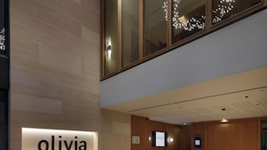 Un interior moderno con una pared de madera, un banco y un letrero que dice 'olivia'.