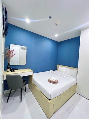 A modern bedroom with a bed, a desk, and a chair.