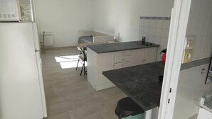 A kitchen with a central island, white cabinets, and a tiled backsplash.