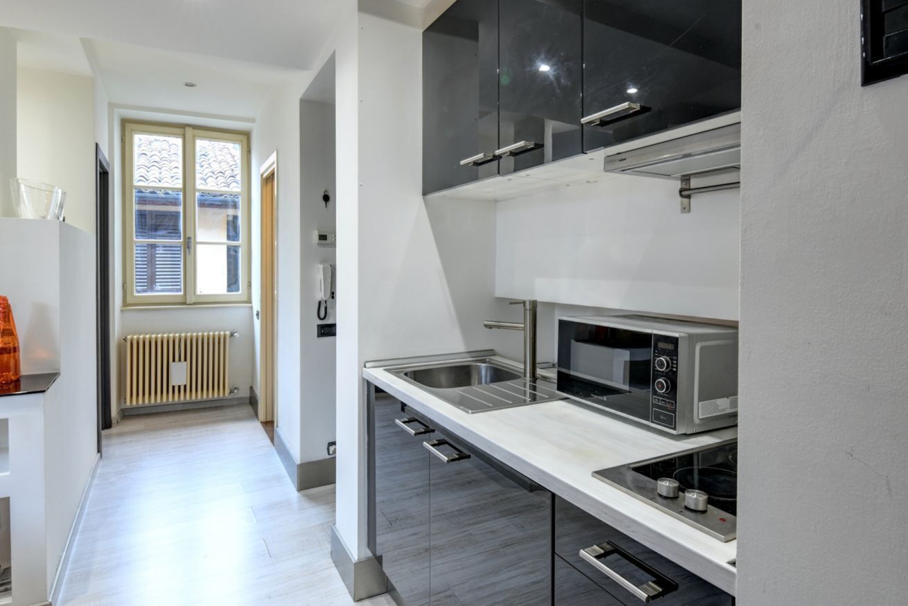 A modern kitchen with a microwave, oven, and stainless steel appliances.