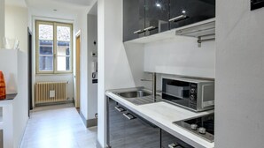 A modern kitchen with a microwave, oven, and stainless steel appliances.