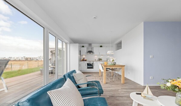 Un appartement moderne doté d’un balcon, d’un coin repas et d’une cuisine.