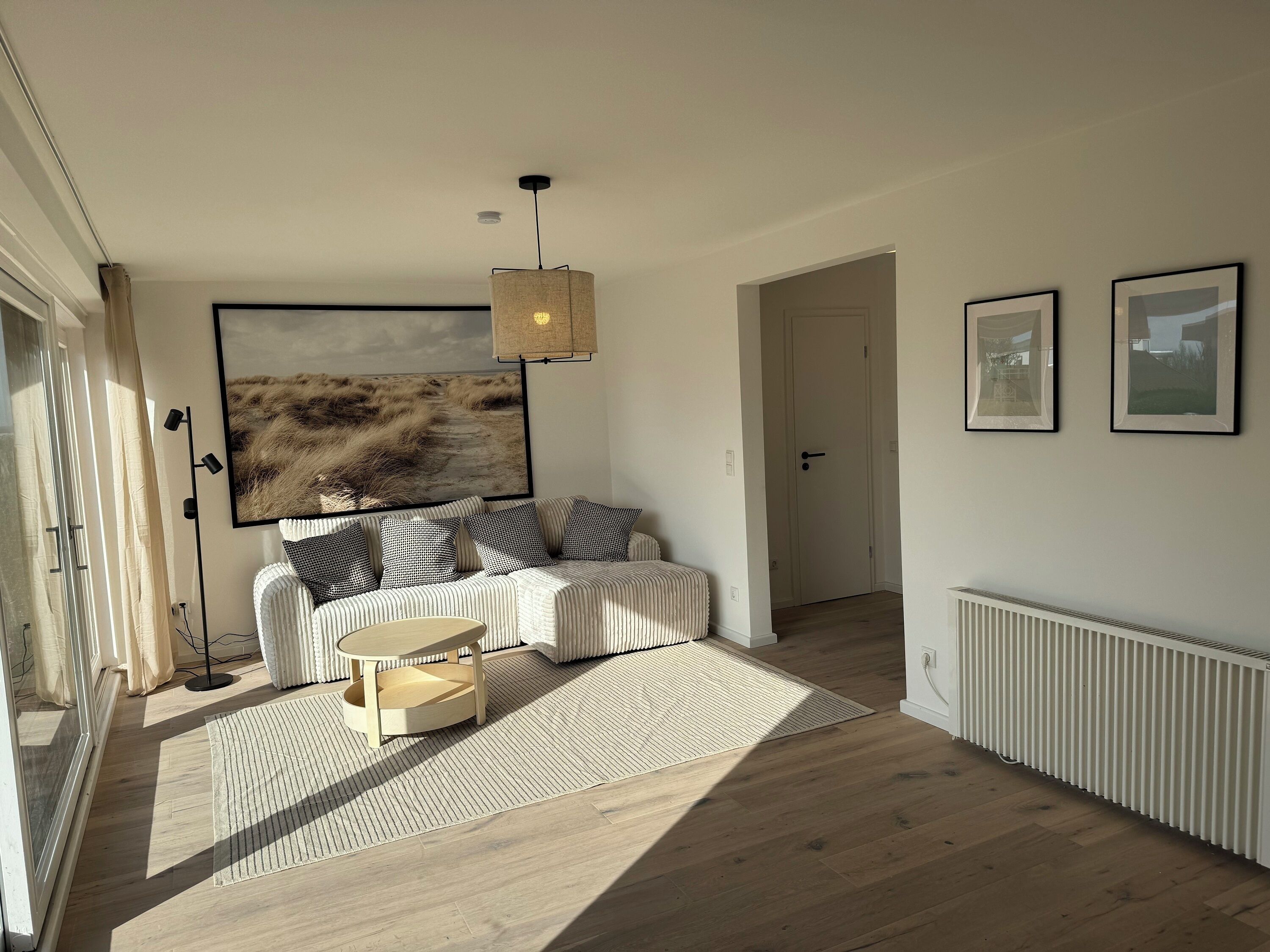 Ein modernes Wohnzimmer mit einer Couch, einem Couchtisch und einem großen abstrakten Gemälde an der Wand.