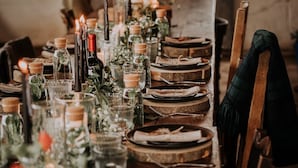 A long dining table set with candles, glass bottles, and plates. - Ginger Hut, Lancaster (Lancaster)