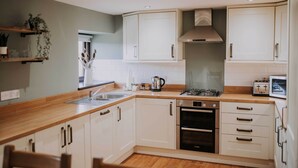 A modern kitchen with white cabinets, a stainless steel range, and a built-in oven. - The Lucky Duck, Patty's Barn, Lancaster, Cockerham (Lancaster)