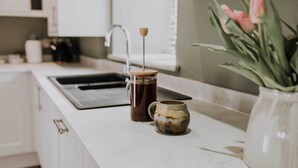 A kitchen counter with a coffee maker, a mug, and a vase with flowers. - 1. The Owl's Look Out, Patty's Barn, Lancaster 4* (Lancaster)
