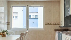 Una cocina con comedor, ventana y vista a un edificio.
