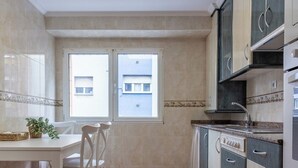 Una cocina con una mesa, sillas, armarios y una ventana.